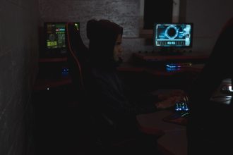 Profissional analisa dados em vários monitores em um ambiente de operações de cibersegurança.