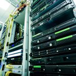 Rack de servidores em um data center, com cabos de rede e componentes de hardware visíveis.