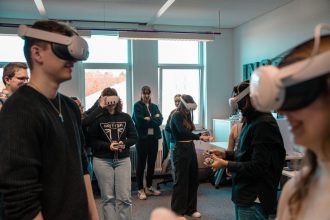 Grupo de adultos usando óculos de realidade virtual em um ambiente de trabalho.