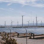 Parque de energia renovável com turbinas eólicas e painéis solares sob céu aberto