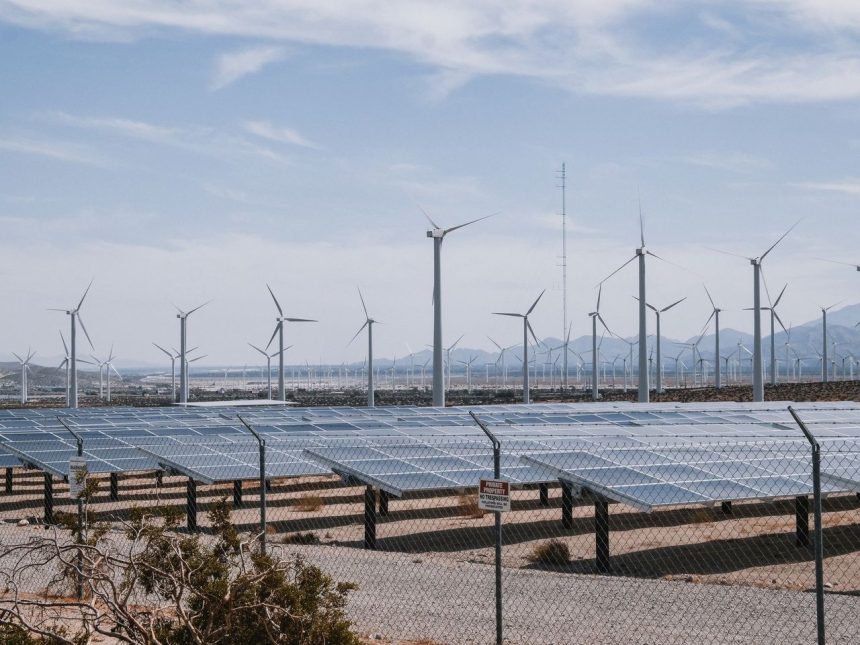 Parque de energia renovável com turbinas eólicas e painéis solares sob céu aberto