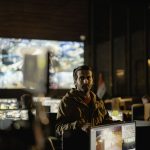 Equipe monitora imagens de câmeras e dados em uma moderna sala de controle operacional.