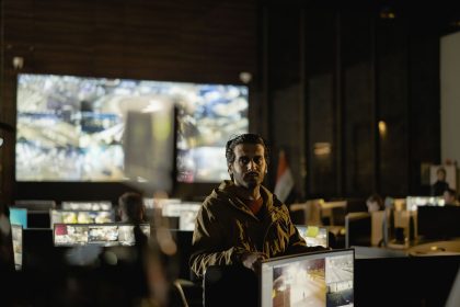 Equipe monitora imagens de câmeras e dados em uma moderna sala de controle operacional.